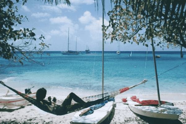 Person being lazy lying in a hammock on the beach