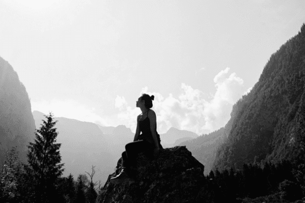 Woman sitting on rock in mountains